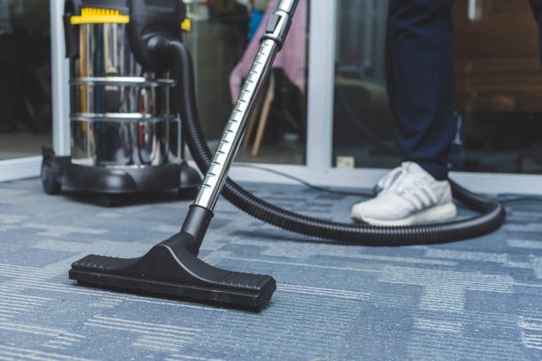 imageye imgi 21 a man cleans the carpet flooring of an office with an upright vacuum cleaner with an attached.jpg