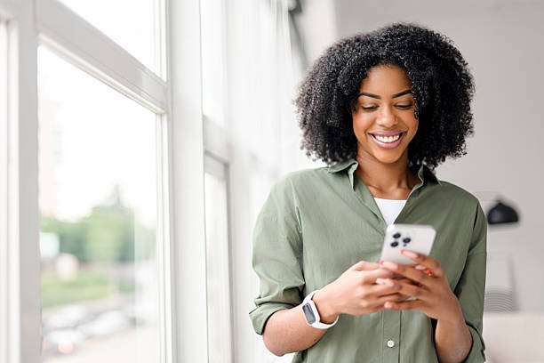 imageye imgi 26 an african american woman with a contagious smile interacts with her smartphone