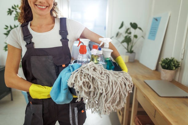 imageye imgi 42 cheerful young housewife holding bucket with cleaning supplies.jpg